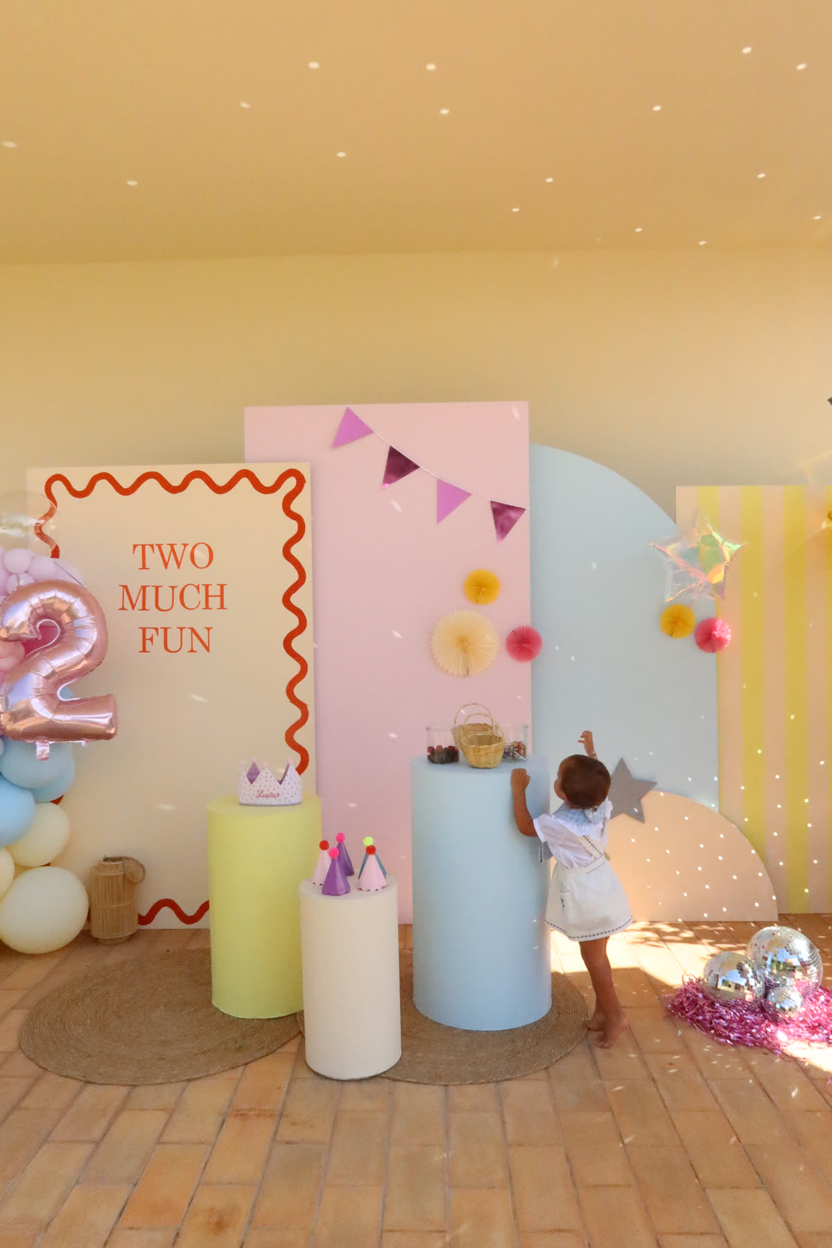 Decoração de festa em tons pastel com painéis, colunas e balões para um segundo aniversário
