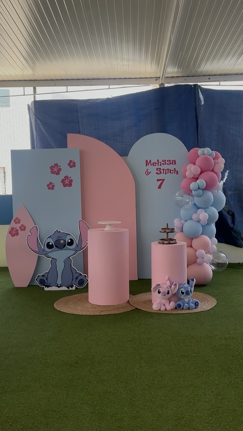 Decoração temática em rosa e azul com painéis arqueados e coluna de balões